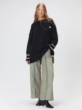 Sweater de punto con diseño de rombos en relieve, cuello redondo y calce holgado. Presenta aberturas laterales en el ruedo y logo bordado en el pecho.