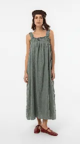 Vestido largo de lino color marrón, de silueta amplia y caída liviana, con escote cuadrado, frunces elastizados en el pecho y breteles anchos con detalles de volados.