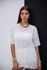 Remeron de encaje blanco con diseño floral, cuello redondo y mangas cortas de corte holgado.
