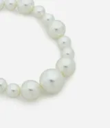 Collar corto de bisutería con perlas artificiales de diferentes tamaños dispuestas en secuencia creciente, con cierre metálico ajustable.
