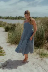 Vestido midi de denim color celeste, con escote recto, breteles finos y corte evasé amplio.