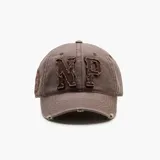Gorra de estilo desgastado color marrón con letras NP bordadas en el frente y detalles de roturas en la visera.