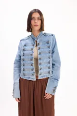 Chaqueta de jean estilo napoleónico color negro, con cuello mao, hombreras y filas dobles de botones metálicos grabados.