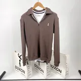 Sweater color marrón con textura tipo waffle, cuello polo, cierre de cremallera parcial y logo bordado en el pecho.