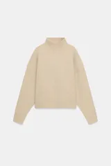 Jersey de punto liso con cuello subido y manga larga, de corte holgado y diseño minimalista.