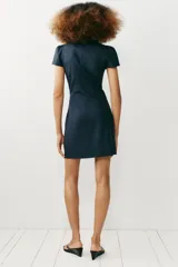 Vestido corto de denim azul con cuello mao, cierre tipo alamar en el pecho, mangas cortas abullonadas y fruncido lateral.