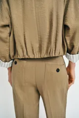 Pantalón recto de tiro bajo en color verde militar, con nervios marcados en la parte delantera, bolsillos frontales y cierre con cremallera, botón interior y ganchos.