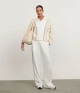 Pantalón deportivo blanco de tiro alto, corte ancho y pierna recta, con friso lateral contrastante.