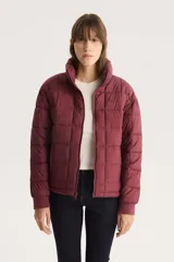 Campera puffer acolchada color borgoña con cuello alto y cierre frontal.