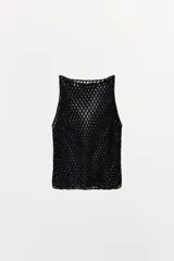 Top negro de tejido de punto abierto con calados en forma de rombos, cuello barco y sisa. Presenta apliques de abalorios a tono.