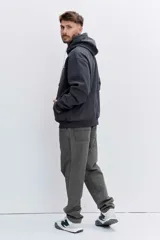 Buzo con capucha tipo canguro confeccionado en tela de corduroy color marrón. Presenta cordones blancos en contraste, bolsillo frontal tipo canguro y logo bordado sutil en el pecho.