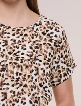 Blusa de silueta holgada y recta, confeccionada en crepe de poliéster con estampado animal print. Presenta escote redondo clásico, mangas cortas de hombro caído con puño doblado y ruedo ligeramente curvo.