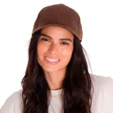 Gorra de béisbol con visera curva, confeccionada en cuero sintético de aspecto desgastado en color marrón. Presenta un pequeño aplique metálico con el logo de la marca en el lateral y cierre ajustable con hebilla metálica en la parte posterior.