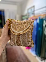 Cartera de mano color camel con bordados de lentejuelas y cuentas blancas, con cadena dorada.