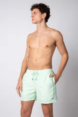 Short de baño color verde menta con efecto desgastado, cintura elástica con cordón ajustable y bolsillos laterales.