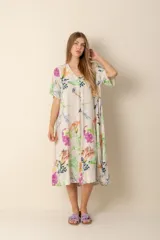 Vestido largo estampado con flores en tonos violeta, naranja, verde y azul sobre un fondo beige claro. Tiene cuello en V y mangas cortas.
