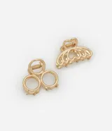 Set de dos pinzas para el pelo doradas, una con forma de corazón y otra con forma circular.