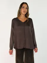 Blusa de satén con cuello en V, corte holgado y mangas largas con caída fluida.