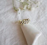 Anillo dorado con diseño de racimo de pequeñas esferas.