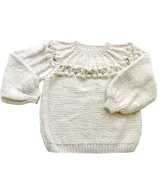 Sweater artesanal de punto en color marfil, confeccionado en pura lana merino. Presenta un amplio canesú decorado con trenzas, bodoques y calados, de mangas largas abullonadas y cuello redondo.