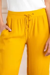 Pantalón palazzo amarillo mostaza de viscosa con cintura elástica y cordón ajustable.