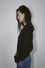 Jersey negro de manga larga con escote en V adornado con encaje negro.