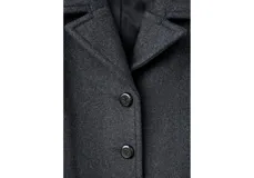Abrigo de paño negro con cuello clásico, cierre frontal de botones y bolsillos laterales. Presenta un corte recto y holgado con mangas largas.