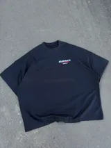 Remera oversize negra con diseño gráfico estampado en el pecho y en la espalda con inscripciones y líneas rojas.