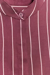 Camisa de cuello subido y manga larga con puños anchos, confeccionada en tejido satinado con diseño de rayas verticales.