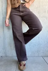 Jean de corte recto y tiro alto en color marrón chocolate, con costuras a contratono y cierre frontal con botón metálico.