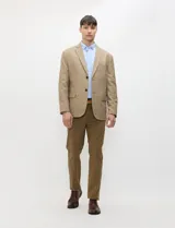Blazer de medio forro, color marrón tostado, con solapas de muesca, cierre frontal de dos botones y bolsillos con solapa. Presenta silueta estructurada.