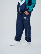 Pantalón de jogging Umbro color azul marino, de corte recto, con cintura elástica y líneas blancas decorativas a los laterales. Presenta el logo de la marca bordado en blanco en la pierna izquierda.
