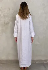 Vestido camisero largo color verde lima, con cuello camisero, mangas largas con puños abotonados, cierre frontal con botones y lazo anudado en la cintura.