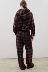 Pantalón de corte amplio y tiro medio-alto, confeccionado en tejido liviano con estampado a cuadros. Presenta cintura elastizada con lazo regulable y bolsillos laterales.