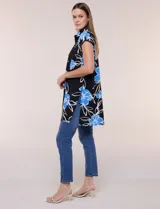 Túnica de gasa negra con estampado floral en tonos azules y blancos, cuello camisero, manga corta y cierre frontal de botones.