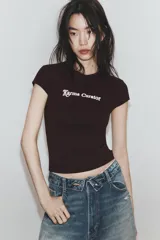 Camiseta slim fit color gris oscuro, con cuello redondo y manga sisa caída. Presenta un texto blanco en el delantero que dice "Main character Role".