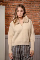 Campera de punto texturizado color beige, con cierre frontal completo y cuello de piel sintética al tono. Presenta mangas largas con puños ajustados y diseño holgado.