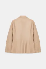 Blazer cruzado de efecto piel color bordó, con solapas de muesca, mangas largas y bolsillos con solapa en la parte delantera. Cierre frontal con botones a tono.