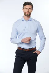 Camisa celeste entallada de manga larga con cuello clásico y cierre frontal con botones. Pantalón de vestir azul marino con cinturón de cuero marrón.