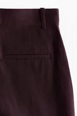 Short de tiro alto color bordó en mezcla de lino, con pliegues frontales, bolsillos al bies y bajos con vuelta cosida.