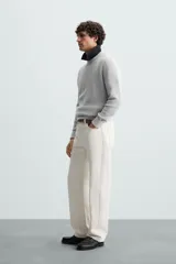 Sweater de punto color beige con textura tipo waffle, cuello redondo y mangas largas con acabado en rib.