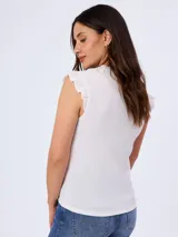 Remera blanca sin mangas con textura fruncida y volados sutiles en los hombros, cuello redondo y corte ajustado.