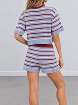 Conjunto de dos piezas confeccionado en tejido de punto a rayas horizontales en tonos celeste, beige y bordó. Incluye una remera de manga corta con cuello redondo y un short con cintura elástica ajustable mediante cordón.