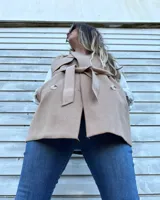 Chaleco color beige con cuello solapa, doble botonadura y lazo para atar en la cintura.