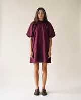 Vestido corto color bordó de lino 100% natural, con silueta amplia y relajada, cuello fruncido y mangas cortas abullonadas con volumen.