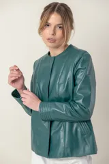 Campera de cuero ovino italiano color verde azulado, con cuello mao, cierre frontal con broches ocultos, bolsillos laterales y detalle de capitoneado en puños y bolsillos.