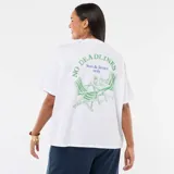 Camiseta blanca de corte oversize, con mangas cortas y un pequeño estampado gráfico verde en el pecho.
