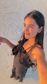 Vestido largo de lino color negro, con escote pronunciado en la espalda y detalle de volados en el escote delantero. Posee tiras finas para atar y tajo lateral.