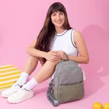 Mochila gris con base verde, de nylon resistente, con cierre principal y bolsillo frontal. Cuenta con detalle en simil cuero y bolsillo pequeño. Bolsillo trasero con cierre y bolsillos laterales. Correas a tono.