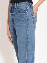 Jeans recto de tiro alto, tipo mom fit, con detalle desflecado en los laterales y diferencia de tonos entre el denim del delantero y de la espalda.